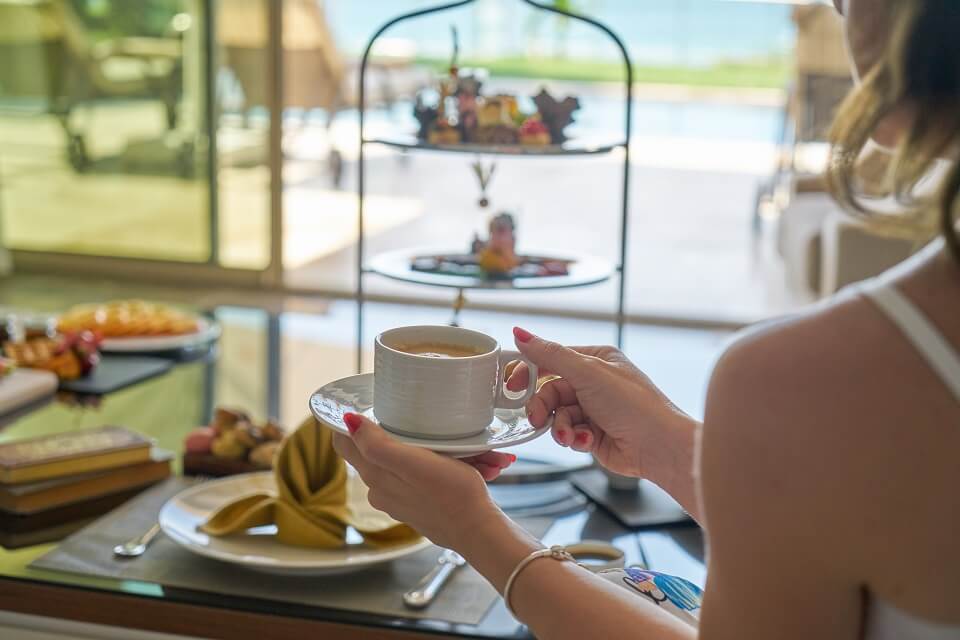 woman holding cup of coffee at hotel buffet