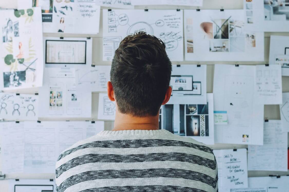 person looking at wall full of notes]
