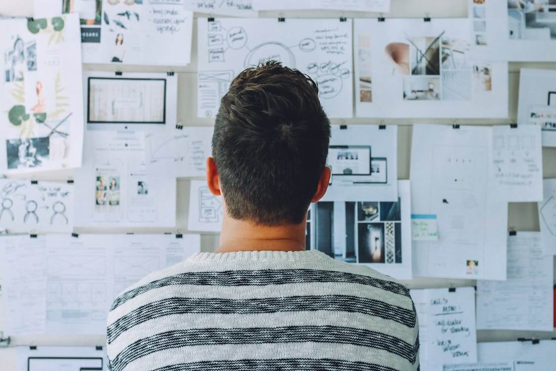 person looking at wall full of notes