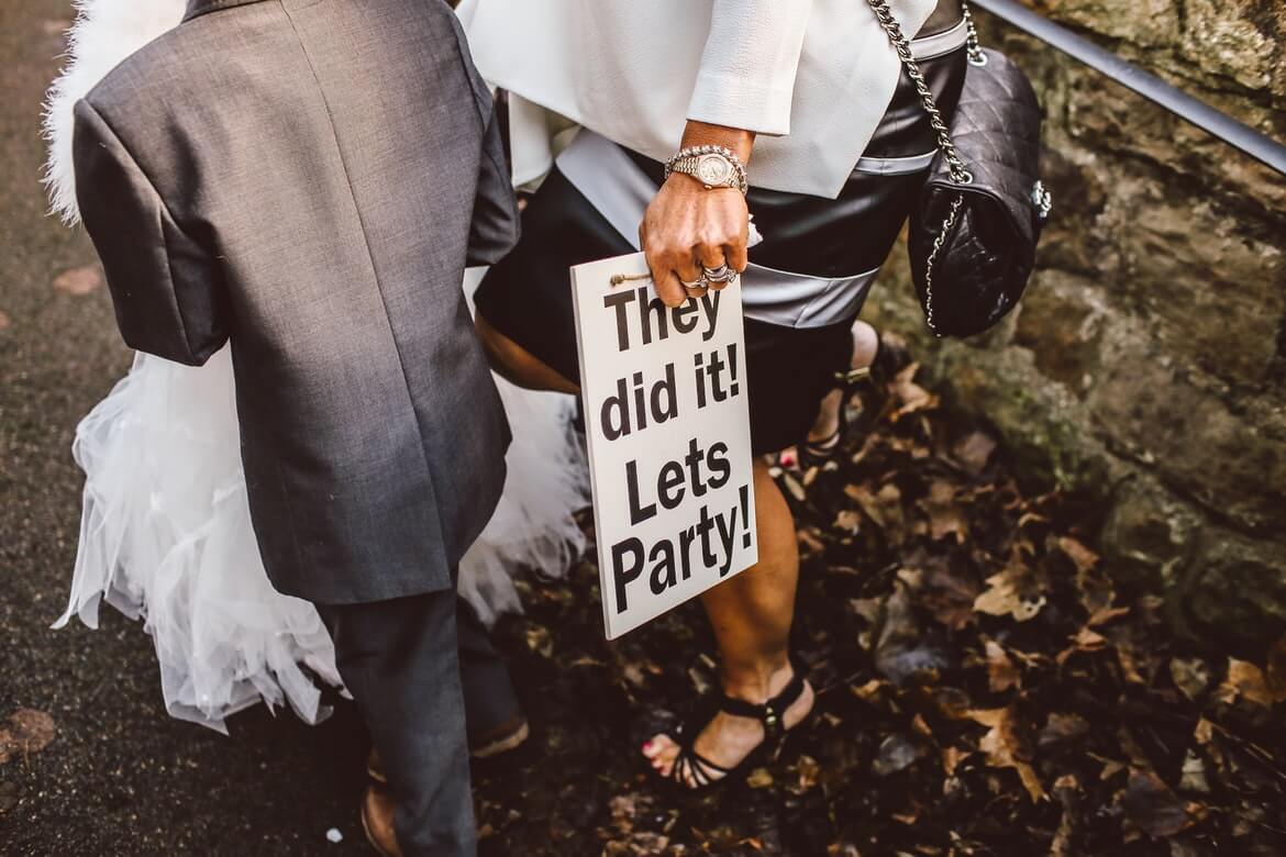 person holding sign: “They did it! Lets Party!”