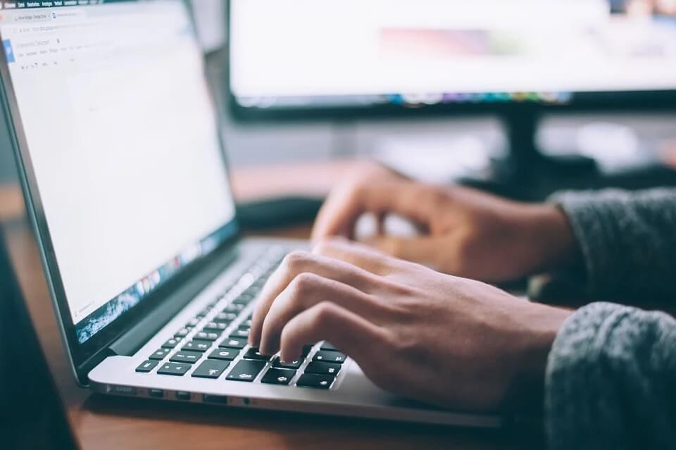 person writing on laptop