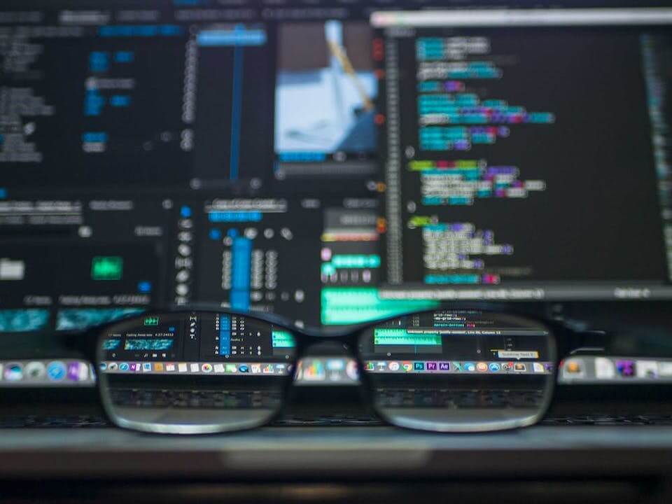 software development concept image - computer screens viewed through eye glasses