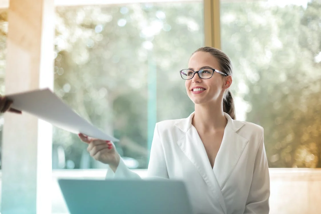 woman handing report to colleague