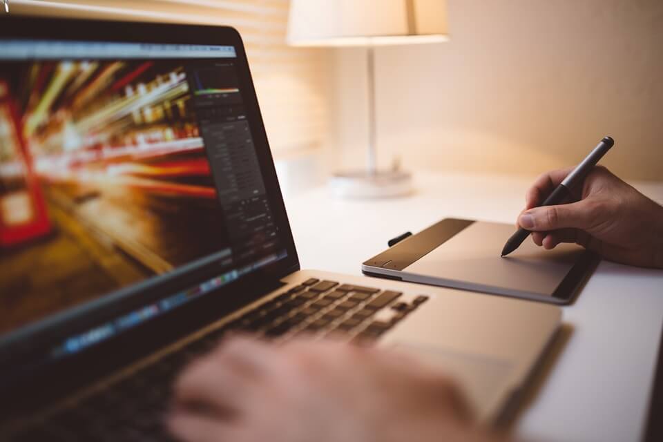 person working on a laptop using a stylus