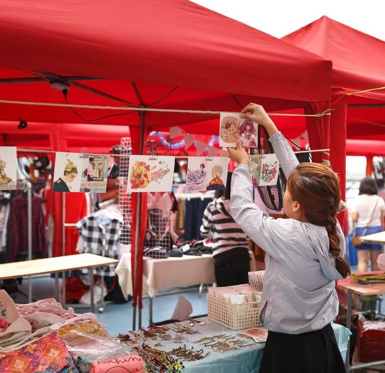 girl hanging photo on outdoor booth