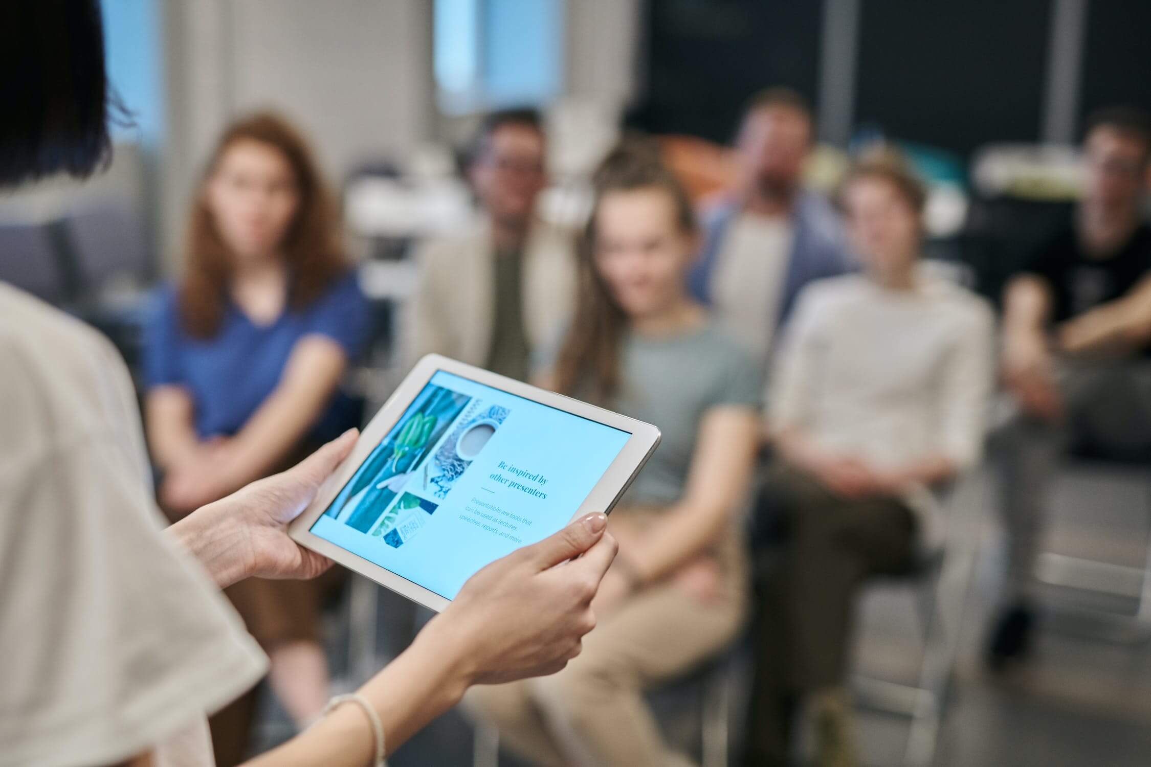 person holding tablet in front of audience