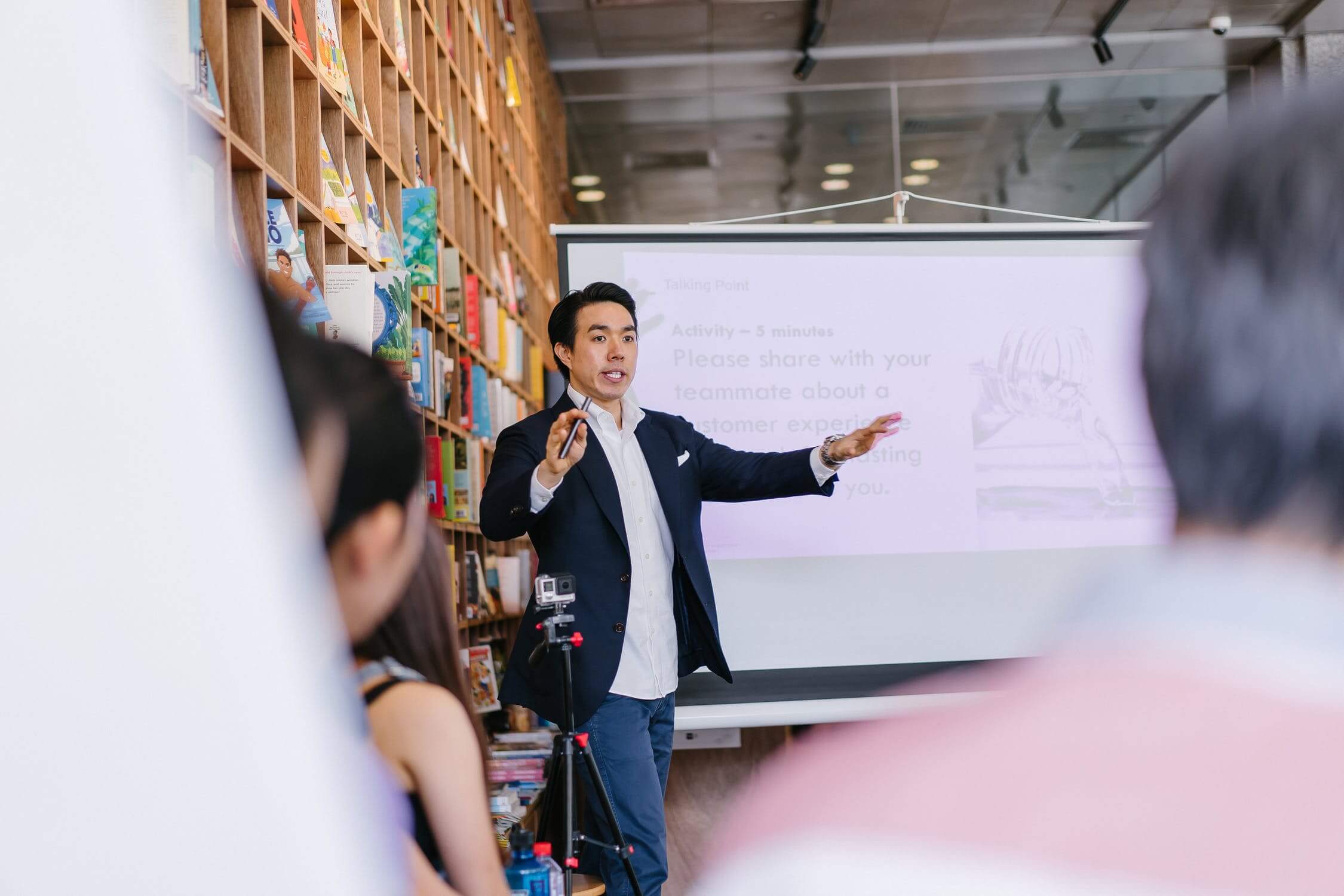 man teaching in front of projector screen